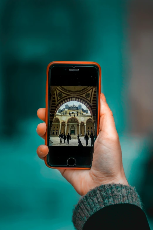 a person taking a picture of a building with a cell phone, a picture, pexels contest winner, renaissance, moroccan mosque, holding it out to the camera, digital reality, color photo