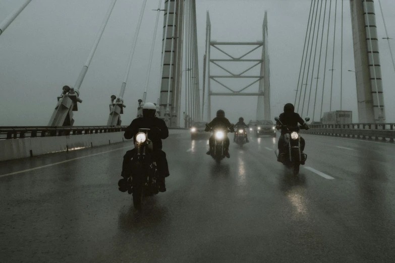 a group of people riding motorcycles across a bridge, pexels contest winner, photorealism, rain and haze, dark cinematic, vintage photo, howrah bridge