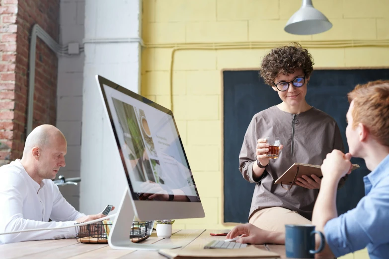 a group of people sitting around a wooden table, a computer rendering, pexels, large computer monitor, rebecca sugar, 9 9 designs, engineer