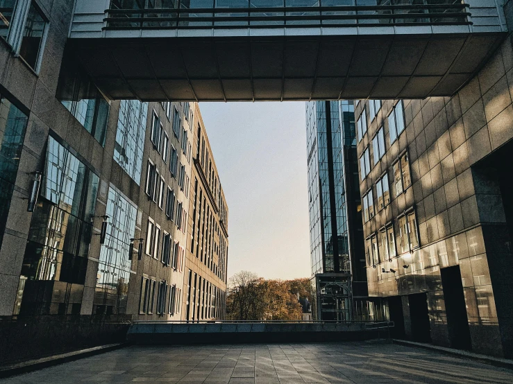 a couple of buildings that are next to each other, by Emma Andijewska, pexels contest winner, brutalism, perfect crisp sunlight, steel archways, fall season, eyelevel perspective image