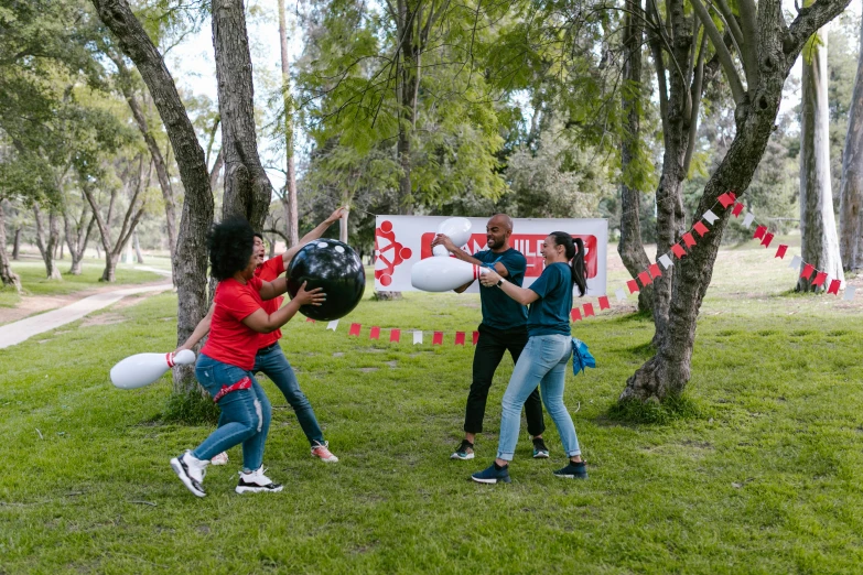 a group of people standing on top of a lush green field, punching in a bag, red flags holiday, at a park, chilean