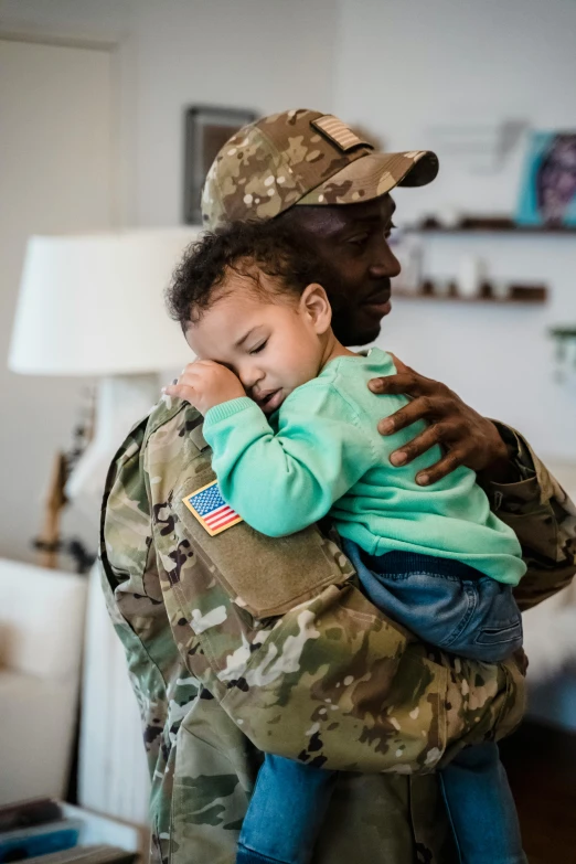 a soldier holding a baby in his arms, pexels contest winner, african american, square, 2 0 2 0 fashion, wounded soldiers