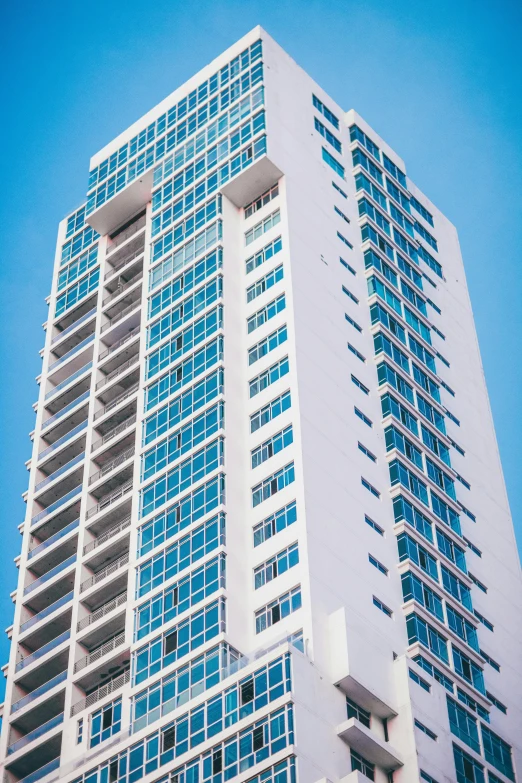 a tall white building with lots of windows, sky blue and white color scheme, miami beach, carson ellis, 8k”