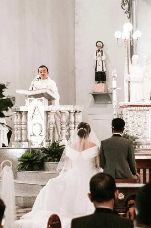 a couple of people that are standing in a church, wearing a wedding dress, giving a speech, darren quach, catholic