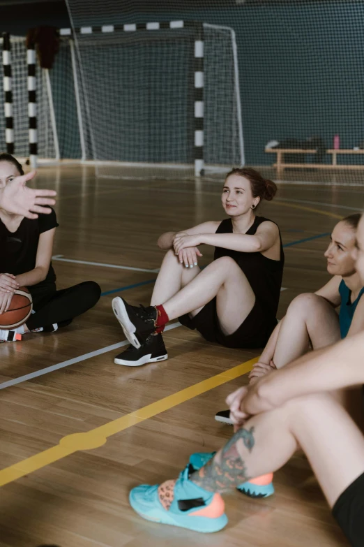 a group of women sitting on top of a basketball court, dark people discussing, nadezhda tikhomirova, instruction, lynn skordal