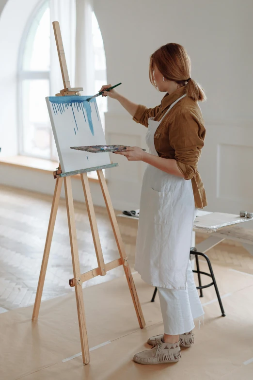 a woman painting on an easel in an empty room, inspired by artist, pexels contest winner, white, glossy paint, paint pour, pristine and clean design