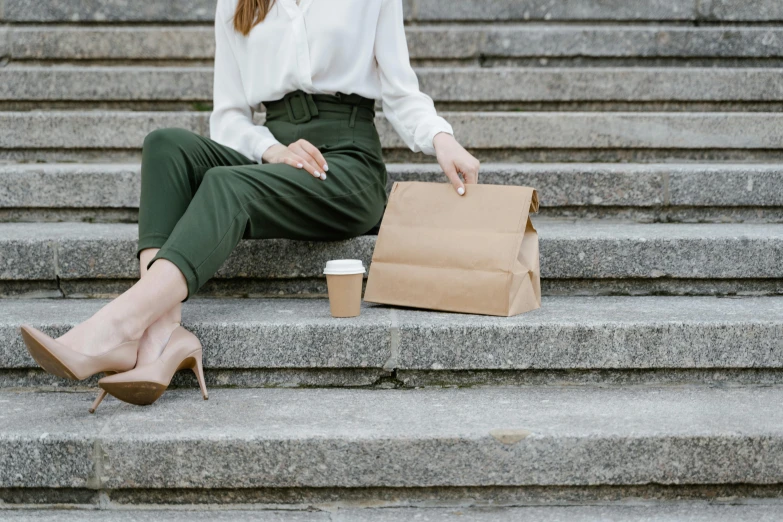 a woman sitting on some steps with a paper bag, trending on pexels, olive green slacks, cold brew coffee ), background image, people outside eating meals