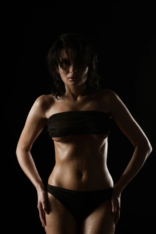 a woman in a black bikini posing for a picture, an album cover, pexels contest winner, sport bra and shirt, serious lighting, taken in the late 2010s, highly textured