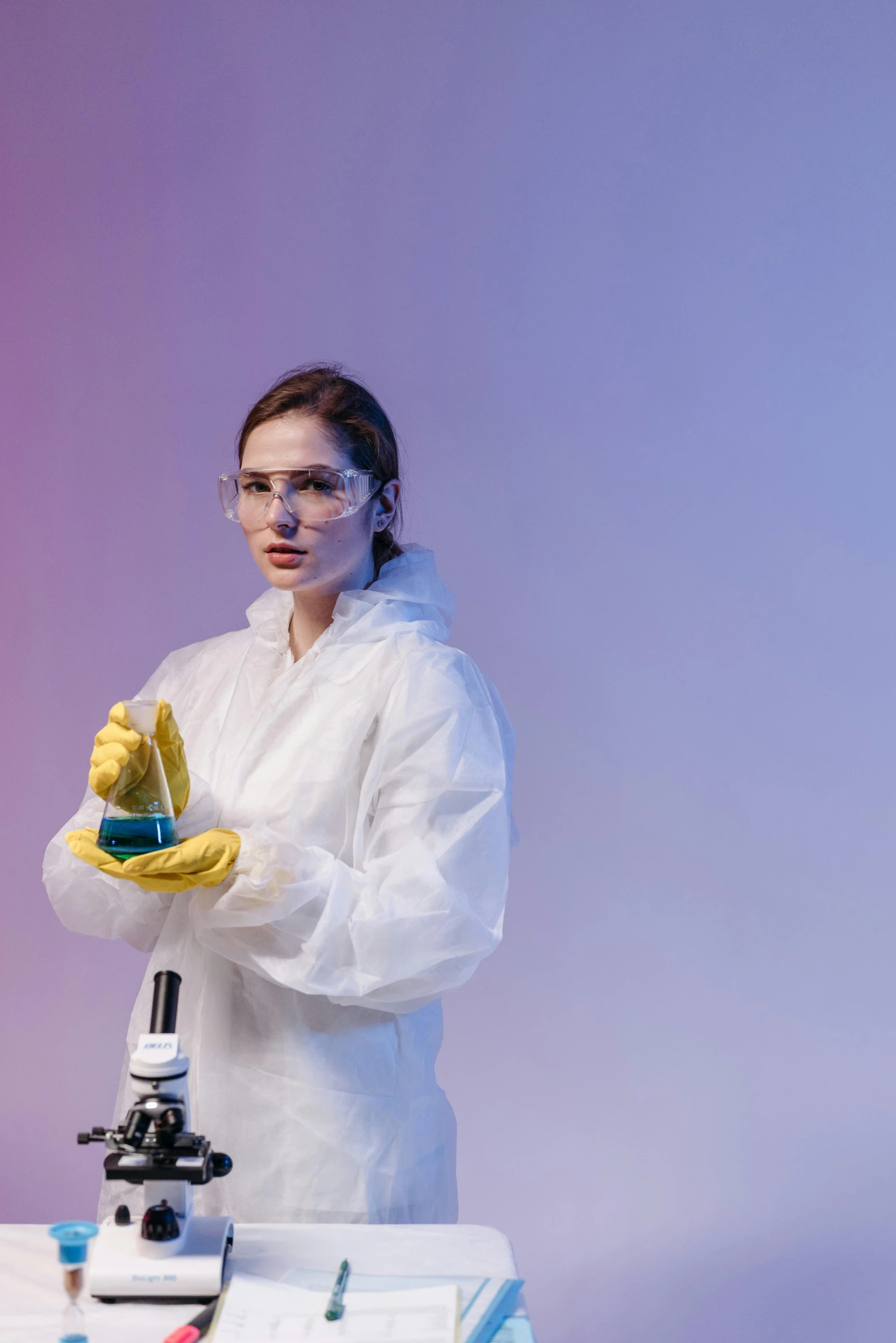 a woman in a lab coat standing in front of a microscope, a portrait, shutterstock, analytical art, yellow latex gloves, holding a small vape, trending photo, dry ice