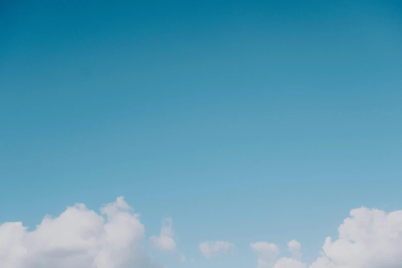 a man flying a kite on top of a lush green field, unsplash, minimalism, cotton clouds, background image, light blues, clemens ascher