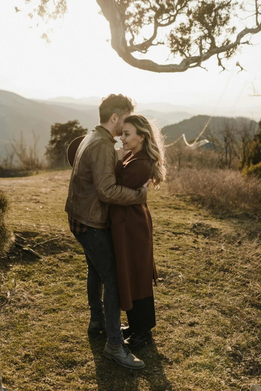 a couple standing next to each other under a tree, pexels contest winner, renaissance, overlooking a valley, wind blowing hair, winter sun, hanging from a hot air balloon