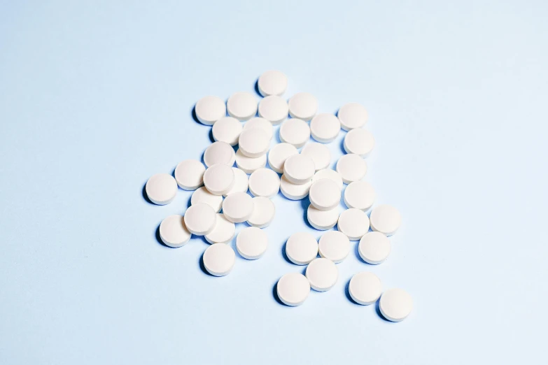 a pile of white pills on a blue background, by Gavin Hamilton, antipodeans, ignant, hedi slimane, sweat drops, with white skin