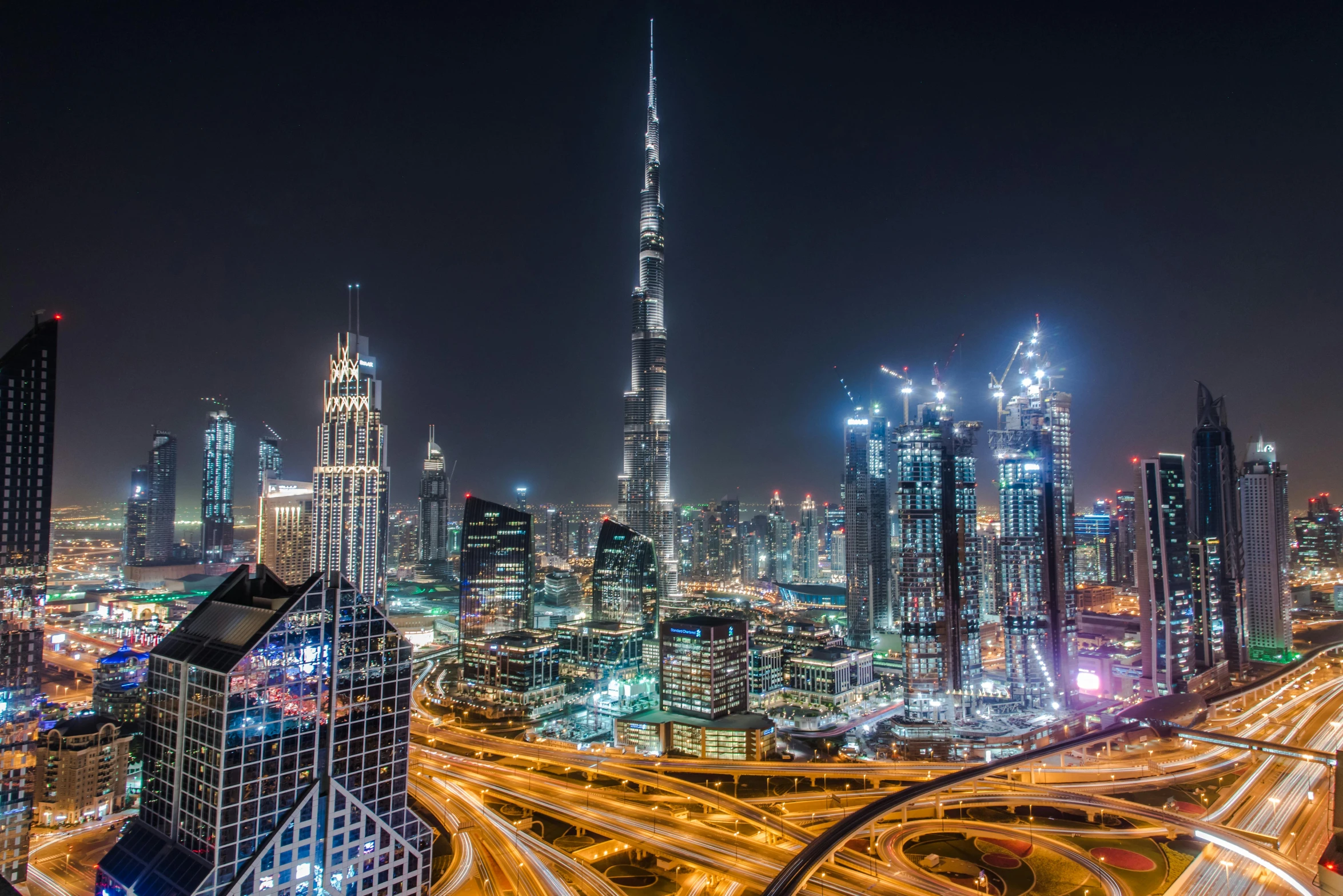 an aerial view of a city at night, pexels contest winner, hurufiyya, dubai, tall buildings in background, youtube thumbnail, stacked image