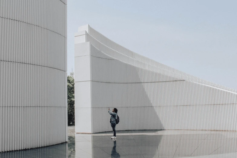a woman standing in front of a white building, inspired by Cheng Jiasui, unsplash contest winner, light and space, parametric architecture, angled walls, schools, monoliths