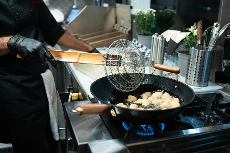 a person cooking food in a frying pan on a stove, restaurant exterior photography, fan favorite, profile image, nets