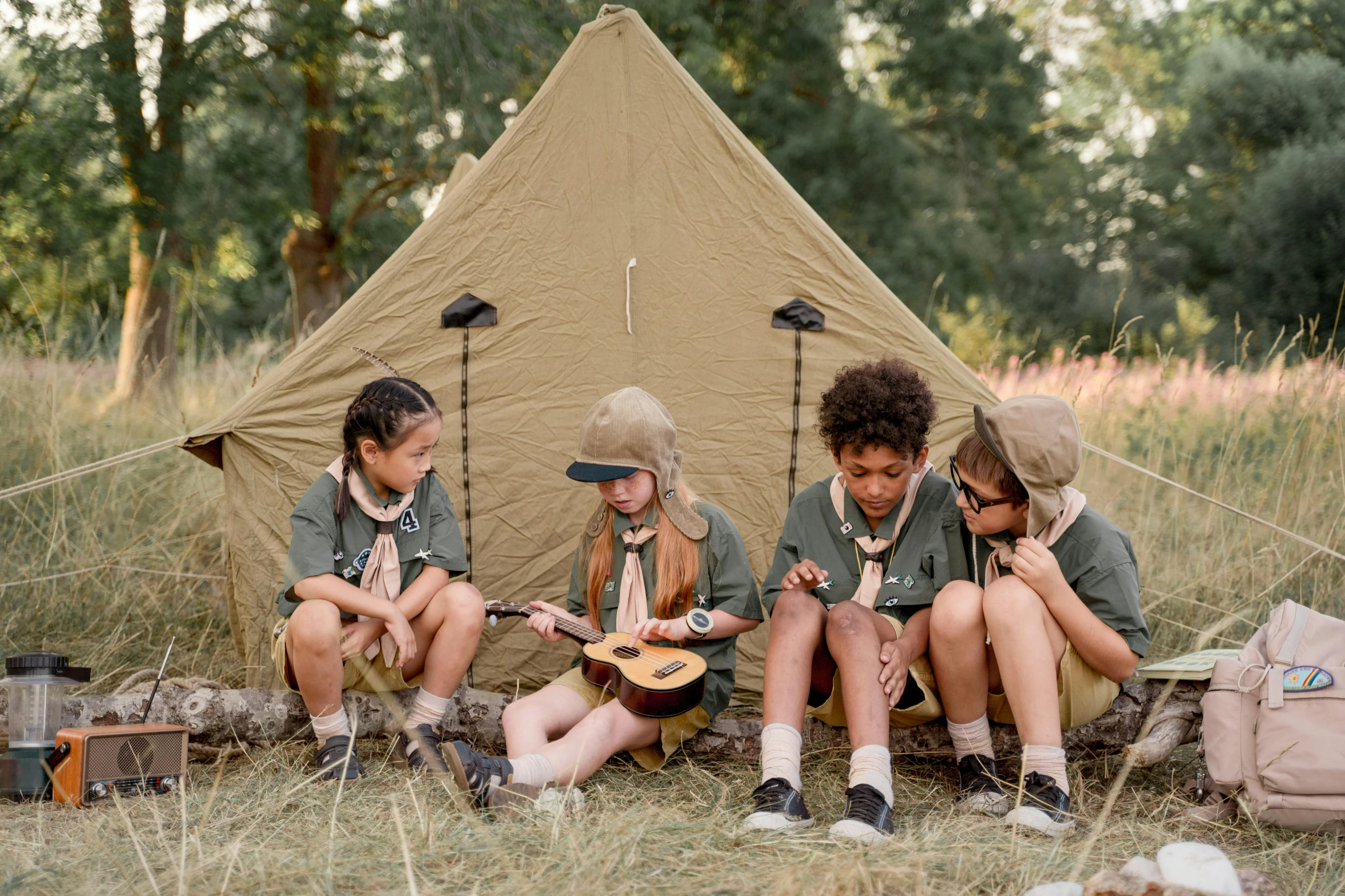 a group of children sitting in front of a tent, an album cover, by Emma Andijewska, trending on unsplash, girl wearing uniform, boy scout troop, manuka, tan