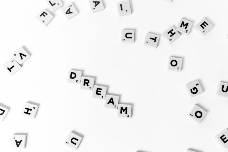 a white table topped with scrabbles and letters, a mosaic, by Matija Jama, pexels, ! dream, on a white background, background image, dream a little dream of me