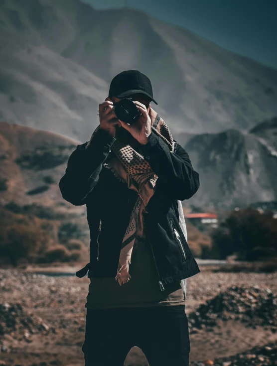 a man taking a picture with a camera, a picture, by Robbie Trevino, unsplash contest winner, rugged details, cinematic outfit photo, hills in the background, streetwear