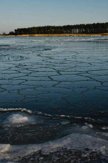 a body of water that has some ice on it, by Jacob Toorenvliet, unsplash contest winner, espoo, low quality photo, looking threatening, plain background