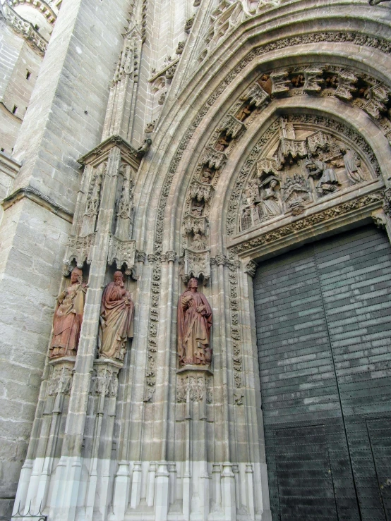 a couple of people standing in front of a building, cathedrals, doorways, up close, stone carvings