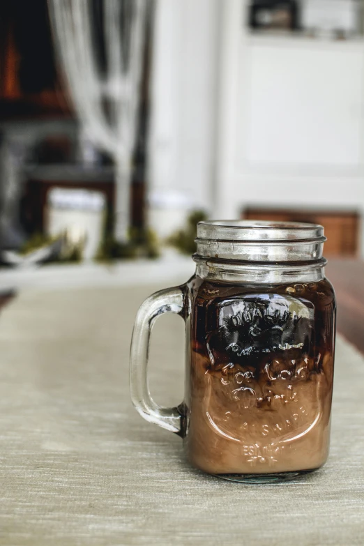 a mason jar sitting on top of a table, ice coffee, profile image