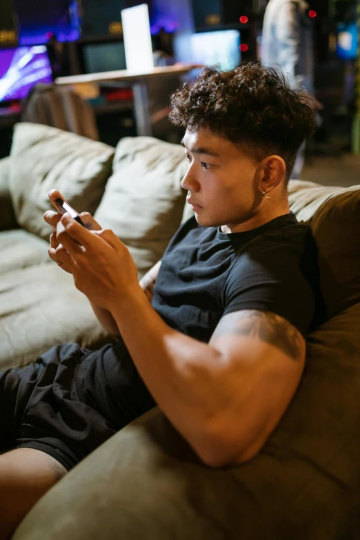 a man sitting on a couch using a cell phone, steroids, darren quach, teenager, game ready