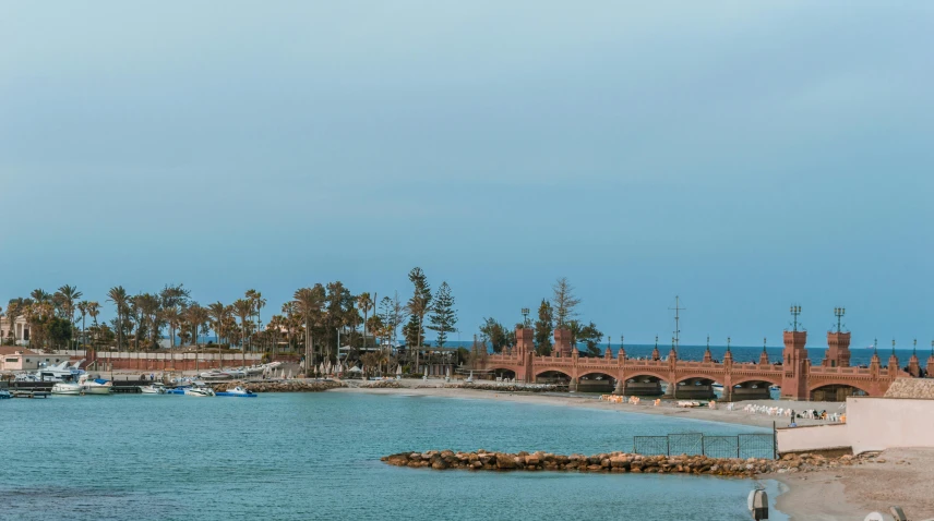 a large body of water next to a beach, by Peter Churcher, pexels contest winner, art nouveau, curved bridge, cyprus, caulfield, listing image