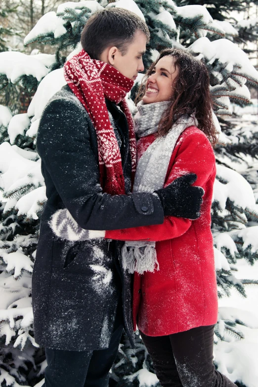 a man and woman standing next to each other in the snow, pexels contest winner, red fabric coat, scarf, promo image, colored photo