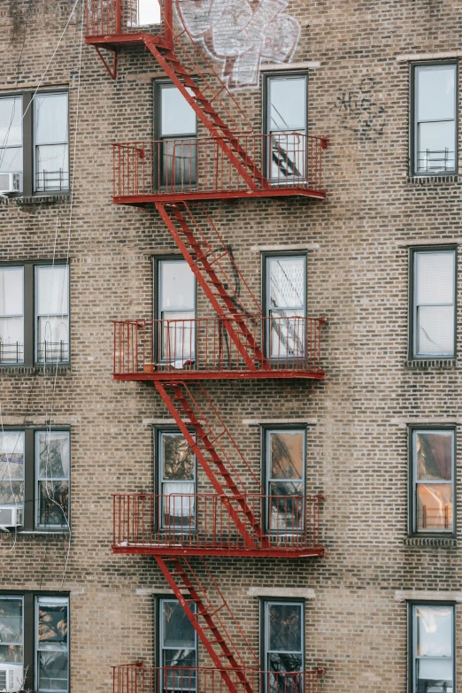 a fire escape ladder on the side of a building, inspired by Elsa Bleda, pexels, harlem renaissance, apartment complex made of tubes, annie lebowitz, square, red roofs