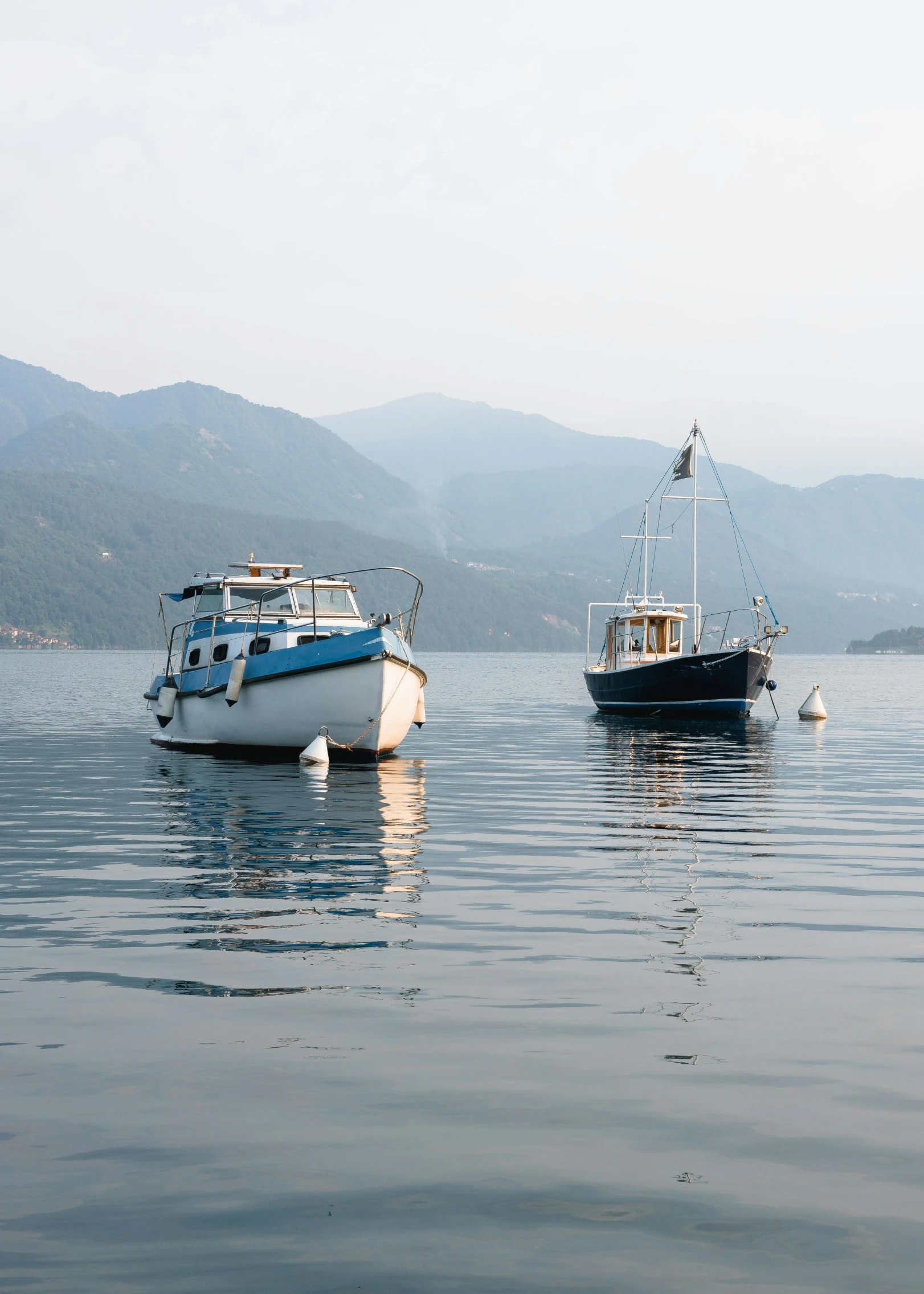 a couple of boats floating on top of a lake, by Exekias, 2022 photograph, maritime, boka, small port village