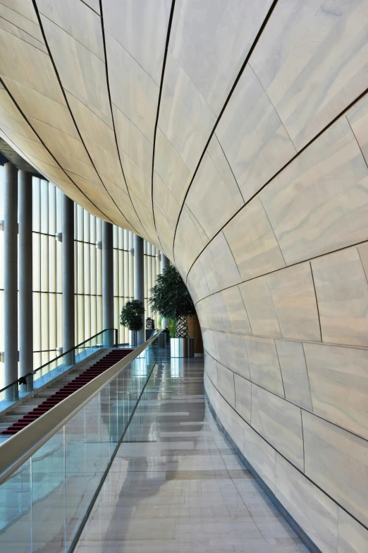 the inside of a building with large windows, inspired by Zha Shibiao, flickr, stone tile hallway, wood panel walls, sleek curves, oman