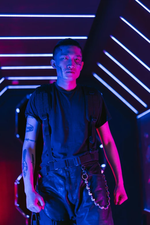 a man standing in front of a neon light, inspired by Zhu Da, symbolism, tactical vests and holsters, shaved sides, concert photo, concerned