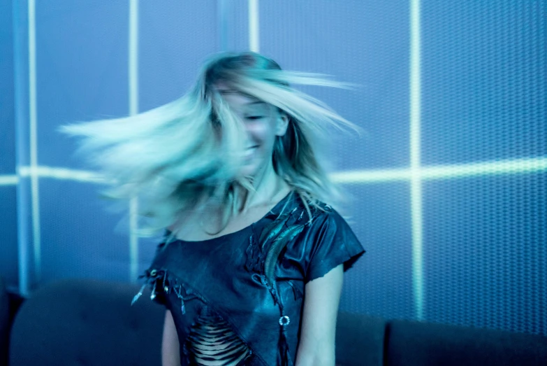 a woman with her hair blowing in the wind, an album cover, inspired by Elsa Bleda, unsplash, happening, nightclub dancing inspired, brightly lit blue room, 15081959 21121991 01012000 4k, loosely cropped