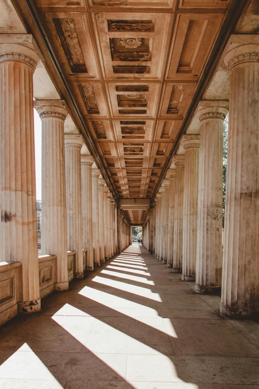 a long hallway with columns and a skylight, an album cover, by Joseph von Führich, unsplash contest winner, neoclassicism, ancient greek temple ruins, wooden banks, sparkling in the sunlight, jerez