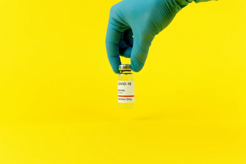 a person in a blue glove holding a vial, on a yellow canva, 2995599206, instagram post, high quality photo