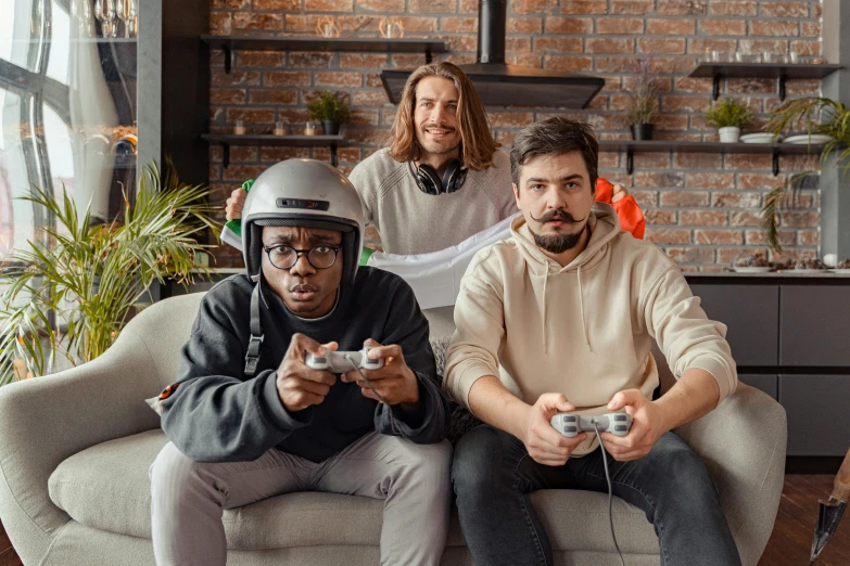 a group of men sitting on top of a couch holding game controllers, pexels contest winner, wearing a round helmet, avatar image, indoor picture, gray men