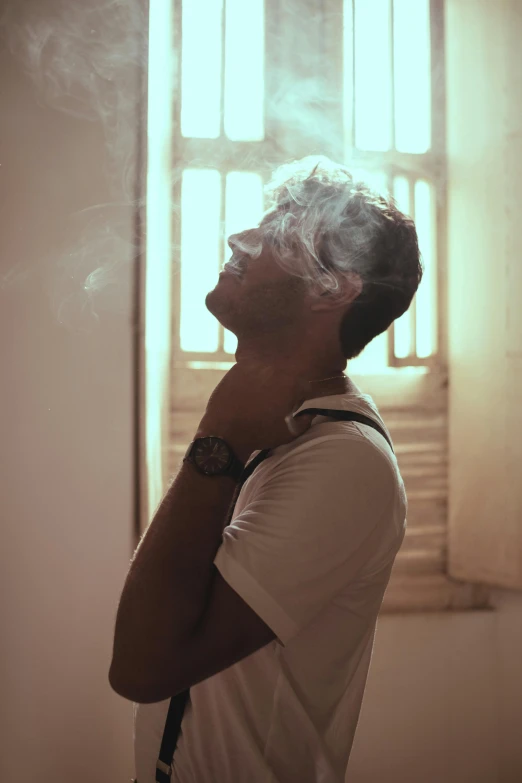 a man standing in front of a window smoking a cigarette, profile image, ganja, lean man with light tan skin, holy rays