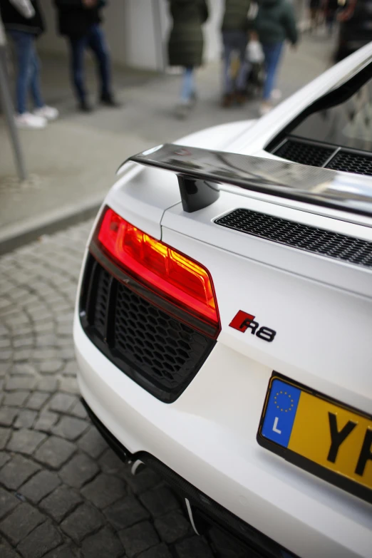 a white sports car parked on the side of a street, rear lighting, 8l, audiophile, sublighting