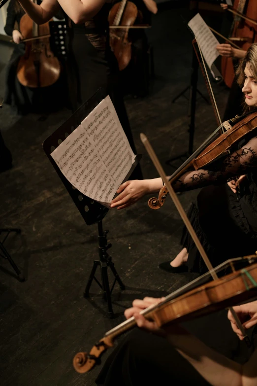 a group of people that are playing musical instruments, standing on top of a violin