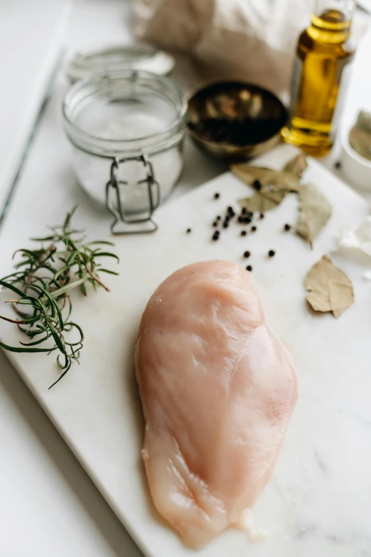 a piece of chicken sitting on top of a cutting board, a picture, trending on pexels, renaissance, smooth marble surfaces, herbs, a pale skin, 6 pack