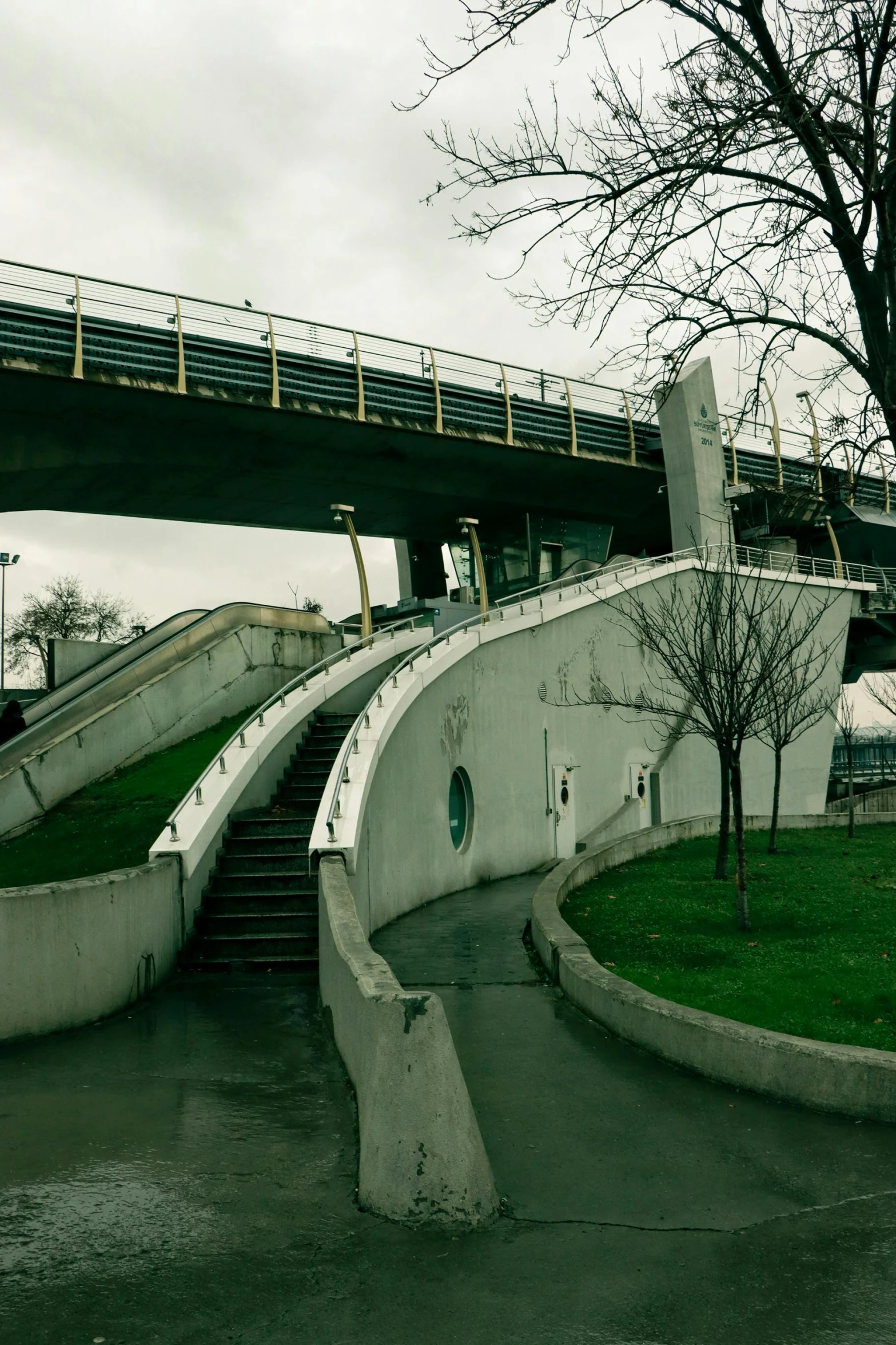 a man riding a skateboard up the side of a ramp, inspired by Otakar Sedloň, reddit, monorail station, exterior view, stairs and arches, on a cloudy day