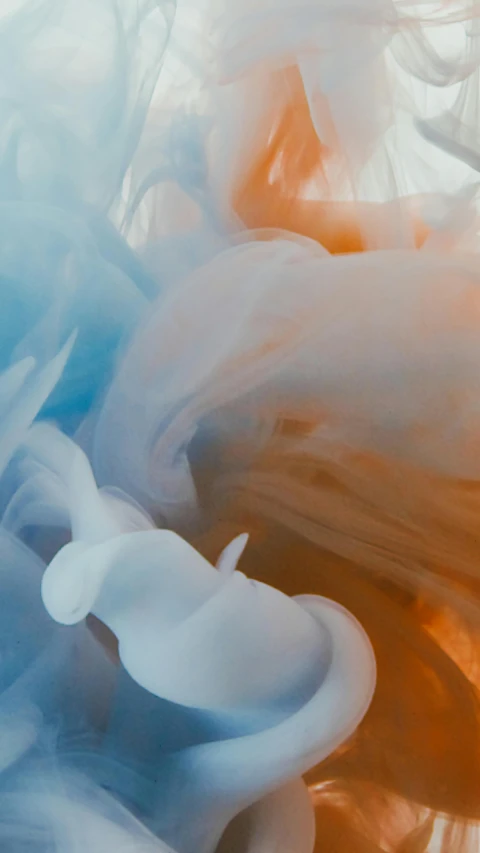 a close up of a white and orange substance, a cartoon, inspired by Kim Keever, unsplash contest winner, whirling blue smoke, various colors, made of liquid, random colors