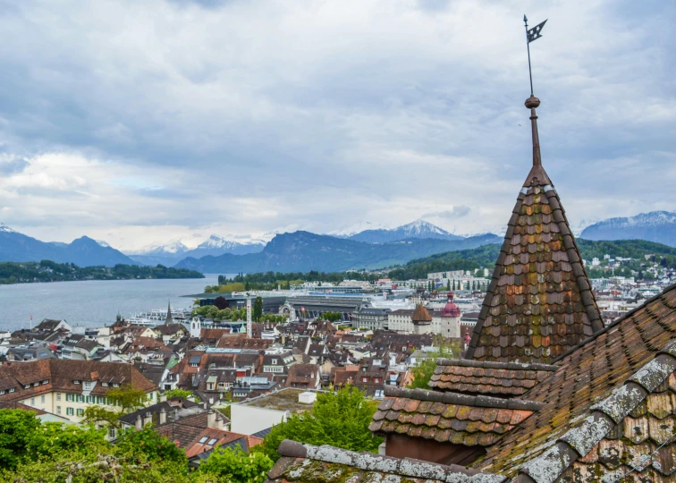 a view of a town with mountains in the background, inspired by Karl Stauffer-Bern, pexels contest winner, renaissance, lead - covered spire, brown, overlooking, lake view