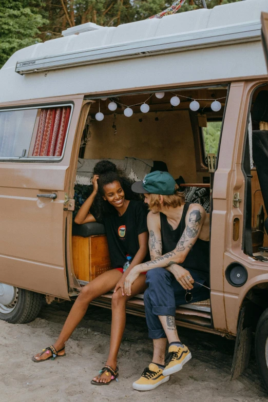 a couple of people sitting in the back of a van, pexels contest winner, renaissance, tan skin a tee shirt and shorts, young women, hippie, black and terracotta