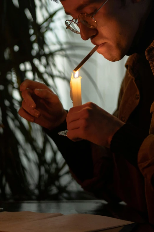 a man lighting a candle in front of a laptop, inspired by Elsa Bleda, ganja, profile image, lowkey lighting, hunter biden smoking crack