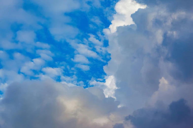 a plane flying through a cloudy blue sky, by Jan Rustem, unsplash, romanticism, colorful dramatic puffy clouds, nature photo, “puffy cloudscape, mixed art