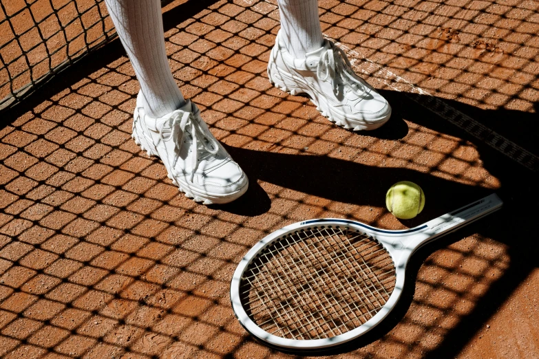 a tennis racket and a tennis ball on a court, an album cover, inspired by Hans Mertens, pexels contest winner, human back legs and sneakers, terracotta, white uniform, photography from vogue magazine