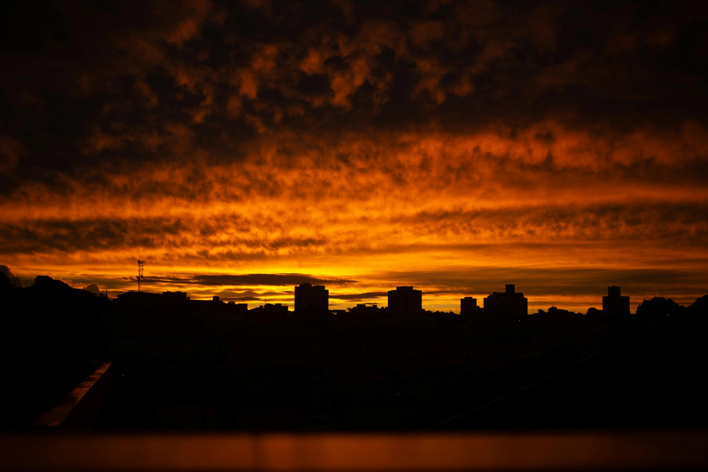 the sun is setting in the sky over a city, by Ian Fairweather, pexels contest winner, hurufiyya, dark orange night sky, silhouette :7, red stormy sky, yellow sky