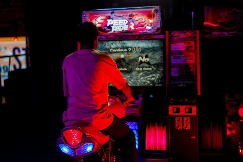 a man playing a video game in a dark room, by Adam Marczyński, pexels contest winner, neogeo, riding a motorbike, fruit machines, red and blue back light, picture of a male biker