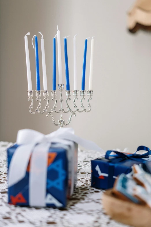 a bunch of blue candles sitting on top of a table, hebrew, presents, chandelier, with a white background